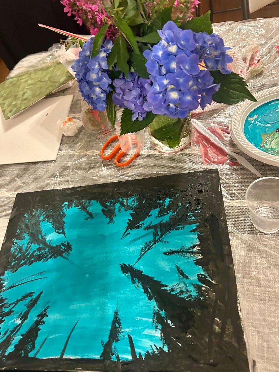 A painting looking up through dark pine trees into a turquoise sky